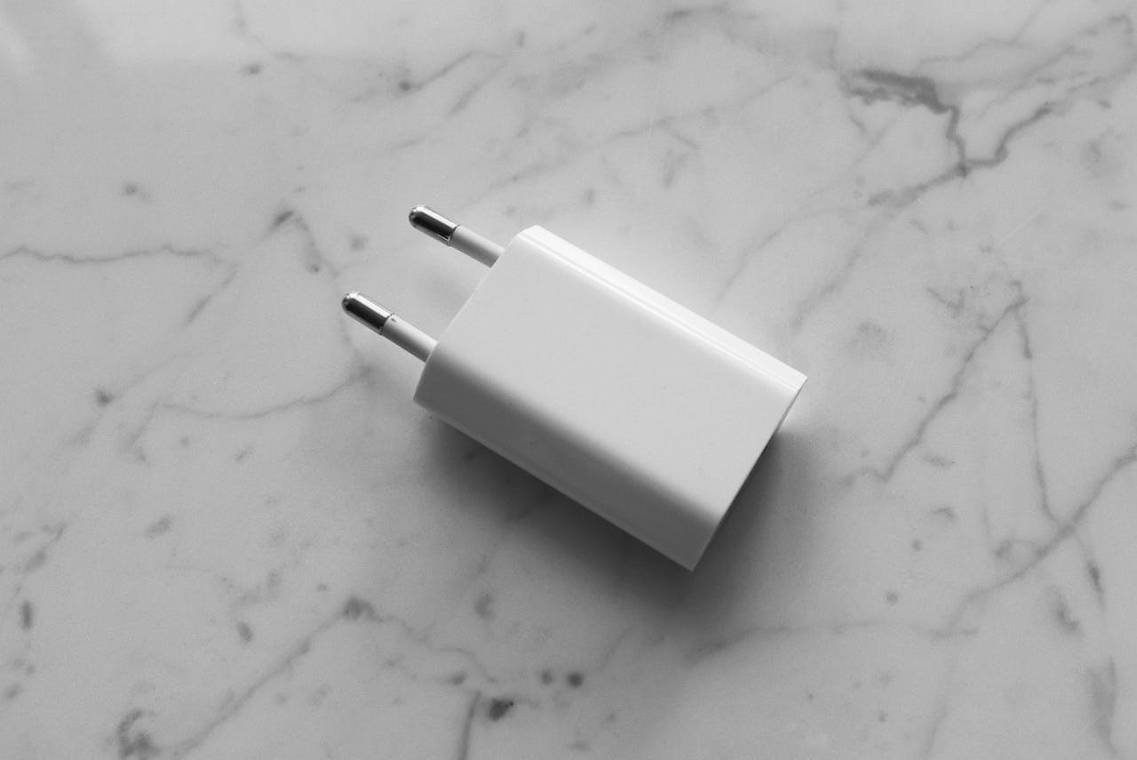 A white adapter placed on a smooth marble surface, showcasing minimalistic design.